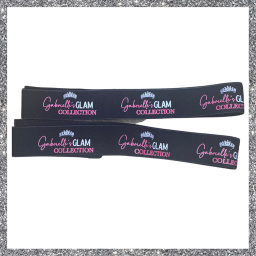 Two black elastic bands with "Gabrielle's GLAM COLLECTION" printed repeatedly in pink script, each above the word "COLLECTION" in smaller, block letters, with a small crown graphic above "Gabrielle's" and a partial print of "Gabrielle's G COLLE" at the end of each band.

